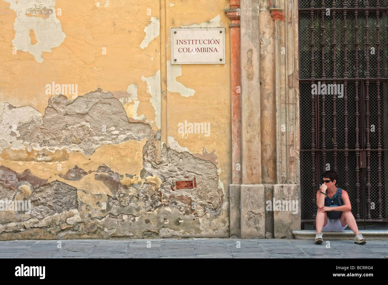 Donna seduta al di fuori del Institucion Colombina, Siviglia centro città, Spagna Foto Stock