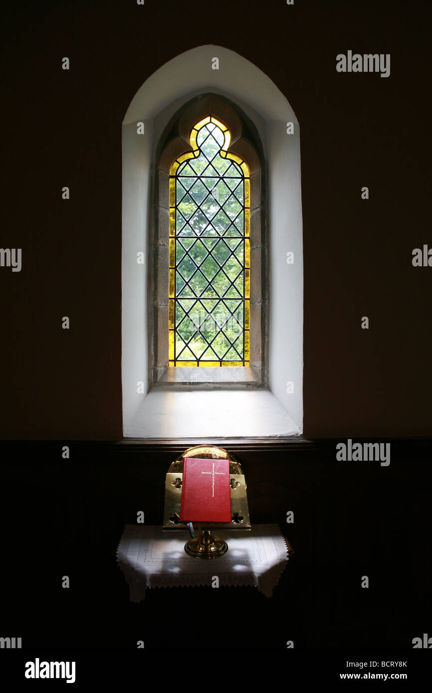 La bibbia in appoggio su un supporto nella finestra di un antica chiesa nello Shropshire, Inghilterra Foto Stock