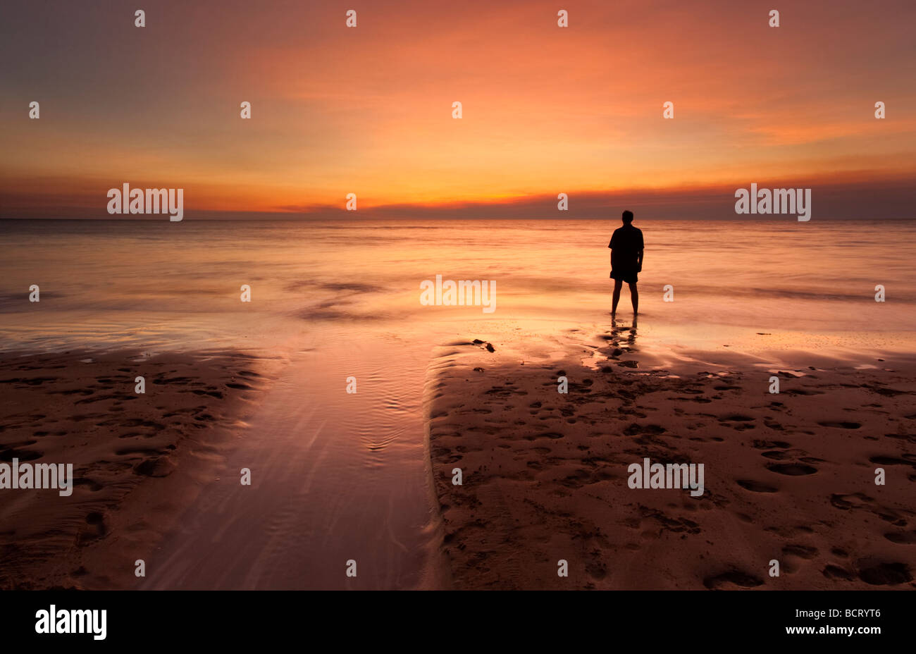 Silhouette di un uomo in piedi sulla riva del mare e guardare il tramonto. Dripstone Beach, Darwin, Territorio del Nord, l'Australia Foto Stock