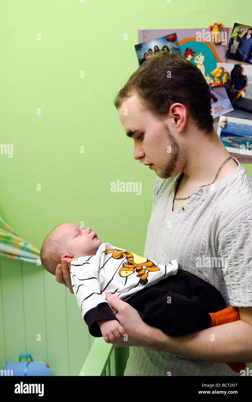 Diciannove anni padre con il suo bambino in camera verde Foto Stock