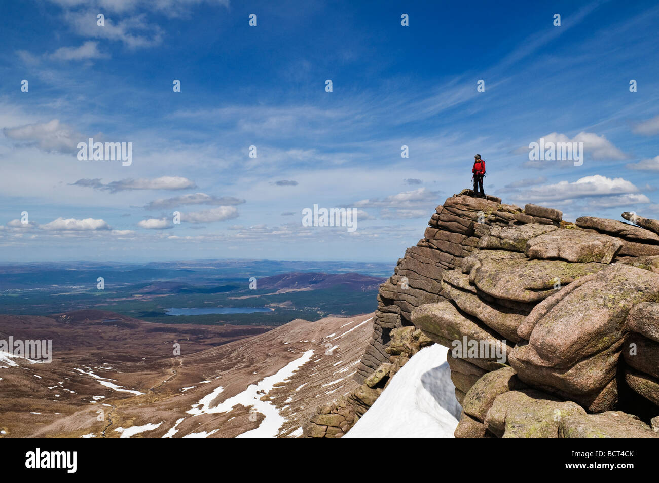 Escursionista femmina si erge il roccioso outlook e gode di vista, Cairngorms National Park, Scozia Foto Stock