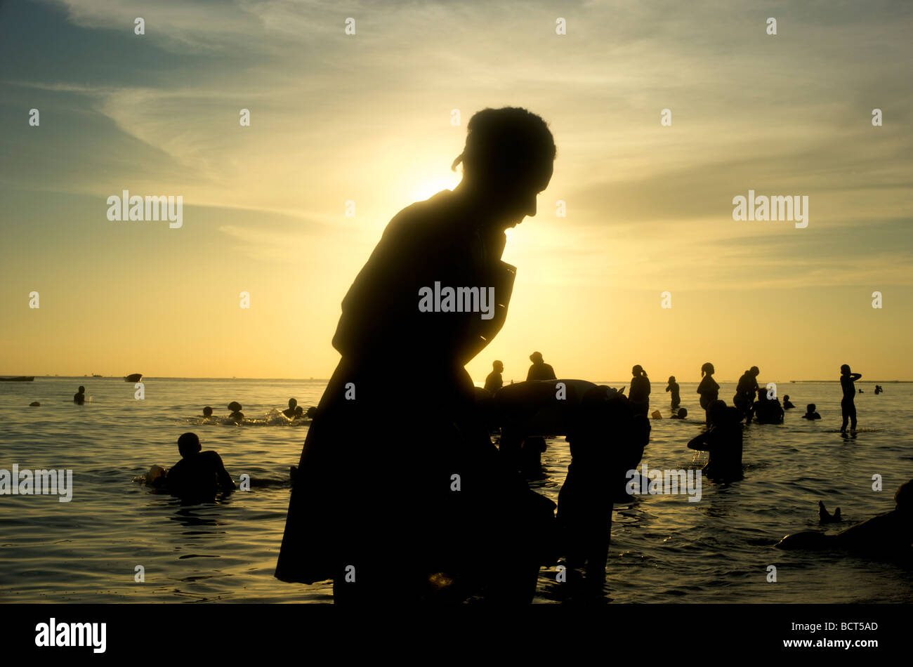 I pellegrini si stagliano nel mare a sunrise rito voodoo a Bord de Mer de Limonade, Haiti il 25 luglio 2008. Foto Stock