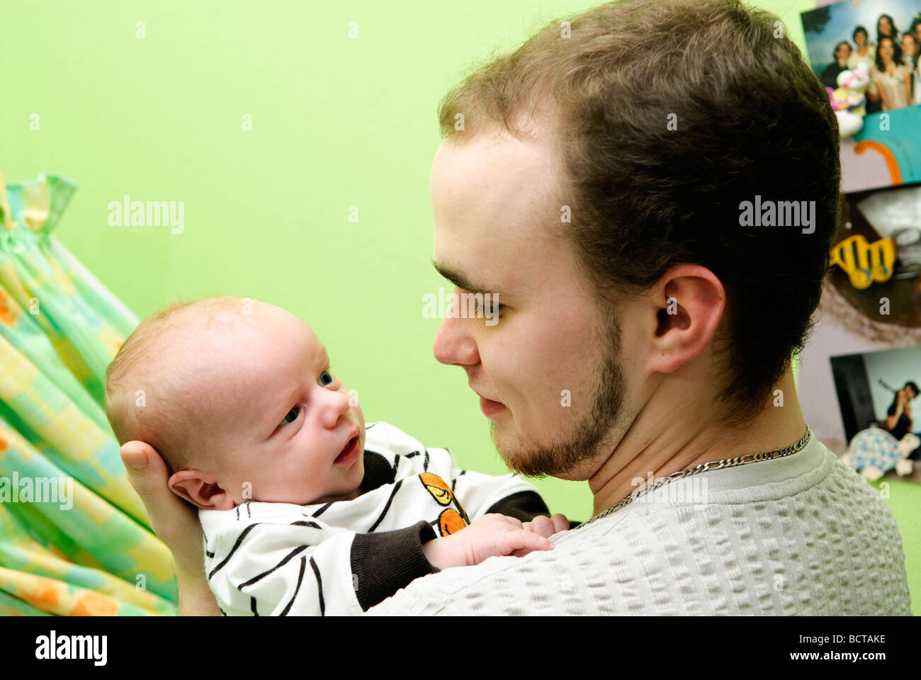 Diciannove anni padre con il suo bambino in camera verde Foto Stock