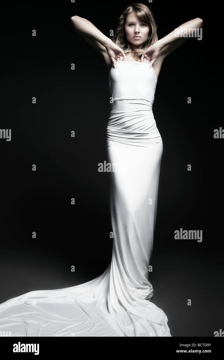 Moda colpo di una giovane donna che indossa un abito bianco e guardando il visore Foto Stock