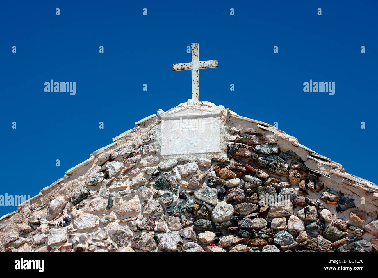 Croce bianca e l'apice di una chiesa ortodossa greca contro un profondo cielo blu Foto Stock