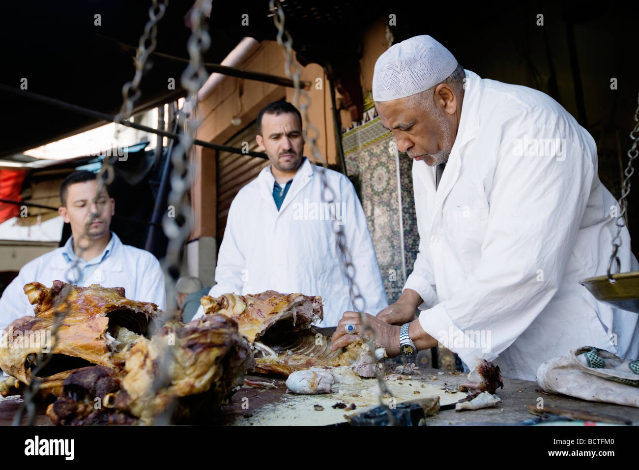 L'uomo vendita di deliziosi piatti a base di carne di agnello in un vicolo del mercato (souk o souq) nella città vecchia (a) Medina di Marrakech, Marocco. Foto Stock
