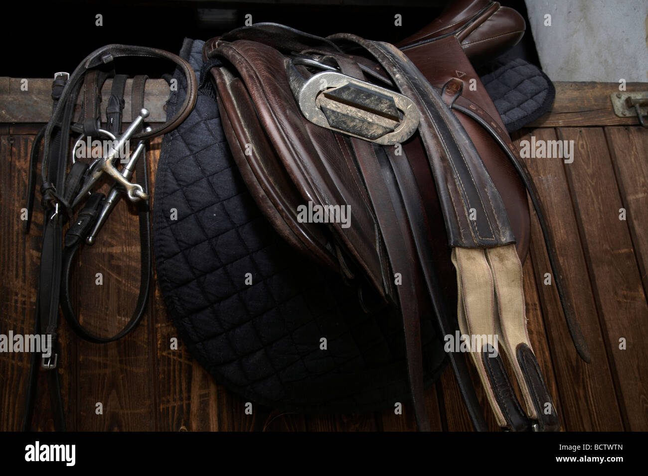 Close up della sella e apparecchiature di equitazione su porta stabile Foto Stock