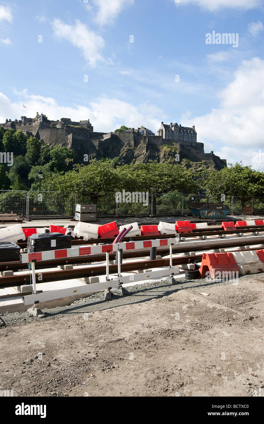 Il tram funziona su Princess street nella capitale Scotlands Edimburgo. Sovrastato dal Castello di Edimburgo situato su Castle Rock Foto Stock