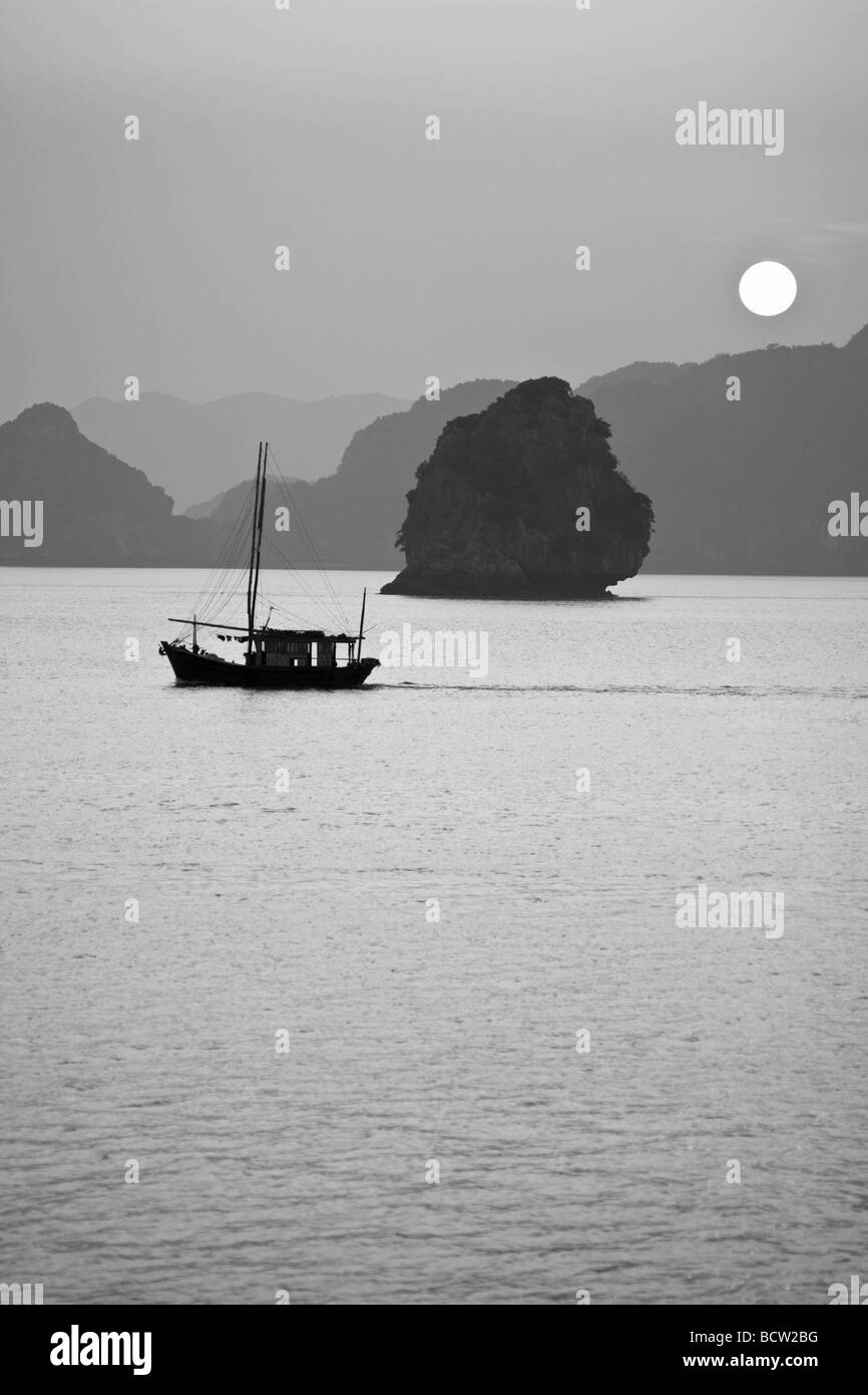 La pesca in barca al tramonto Baia di Halong Vietnam Foto Stock