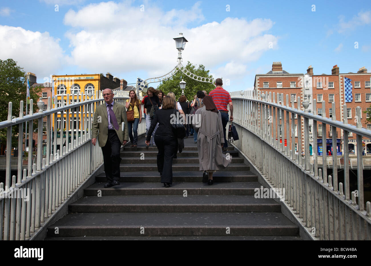 Pedoni che attraversano la halfpenny hapenny ponte sopra il fiume Liffey nel centro della città di Dublino Repubblica di Irlanda Foto Stock