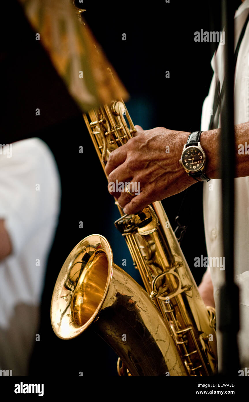Un uomo latino suona il sassofono durante un live music performance. Foto Stock