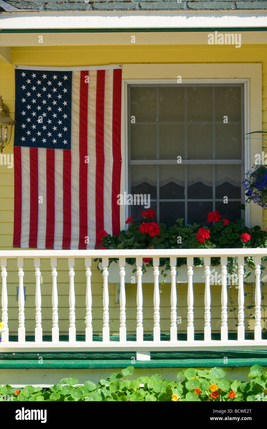 Bandiera americana appesa sotto il portico di un edificio Foto Stock
