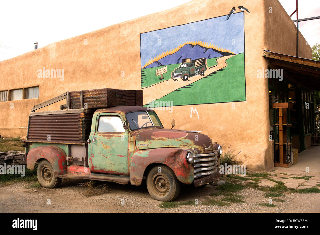 Murale su una parete con un vecchio carrello di fronte ad esso, Nuovo Messico, STATI UNITI D'AMERICA Foto Stock
