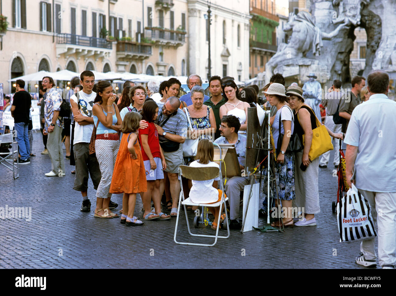 Uomo di disegno di un ritratto di una ragazza in un gruppo, Piazza Navona, Roma, Lazio, l'Italia, Europa Foto Stock