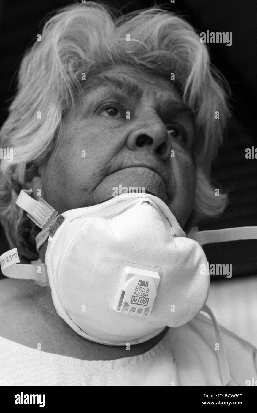 Vecchia donna proteggendo dall'influenza suina Foto Stock