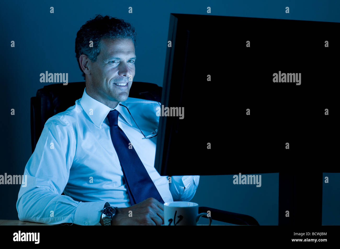 Imprenditore maturo a lavorare fino a tarda notte nel suo ufficio Foto Stock