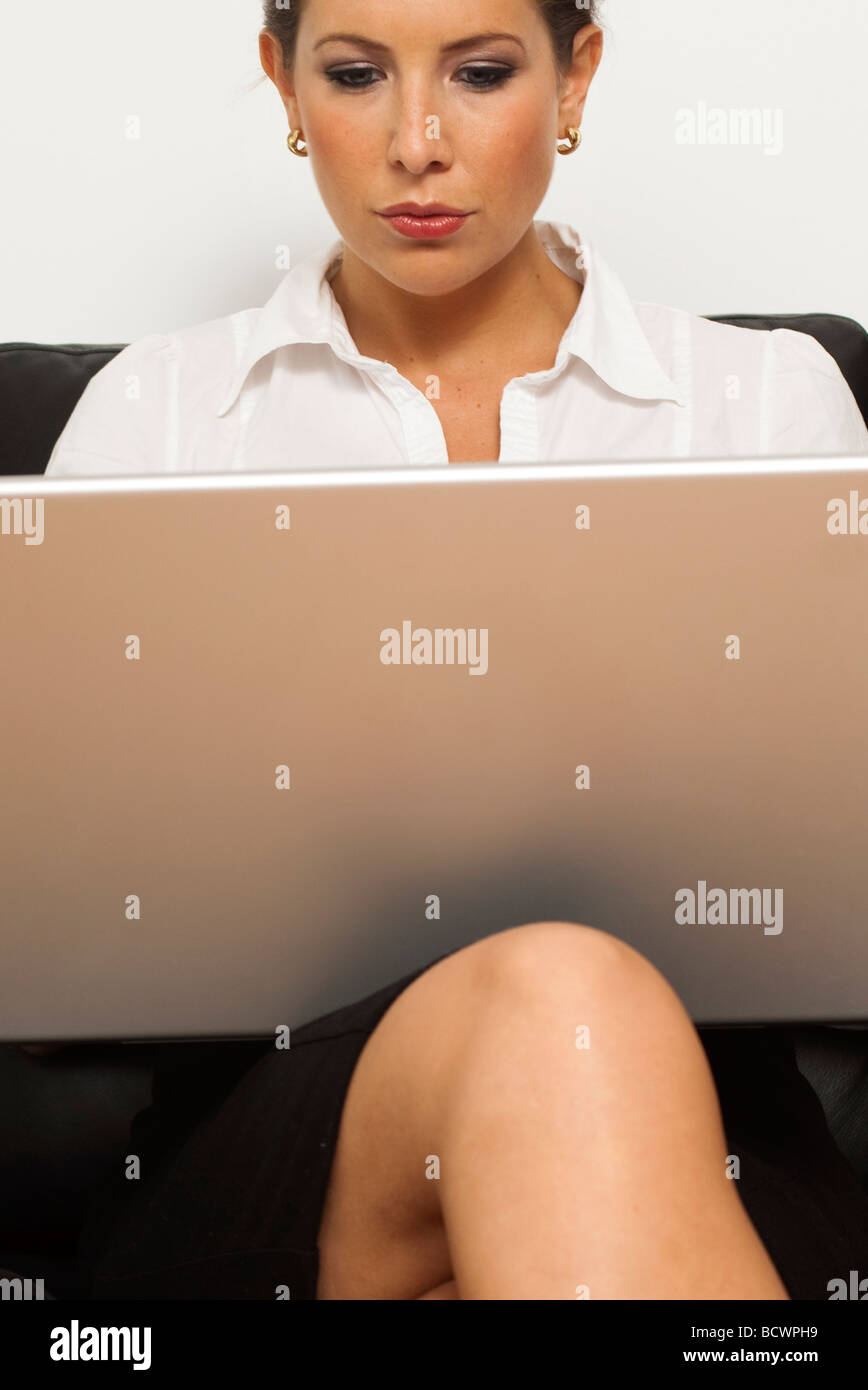 Donna al lavoro su il suo computer portatile Foto Stock