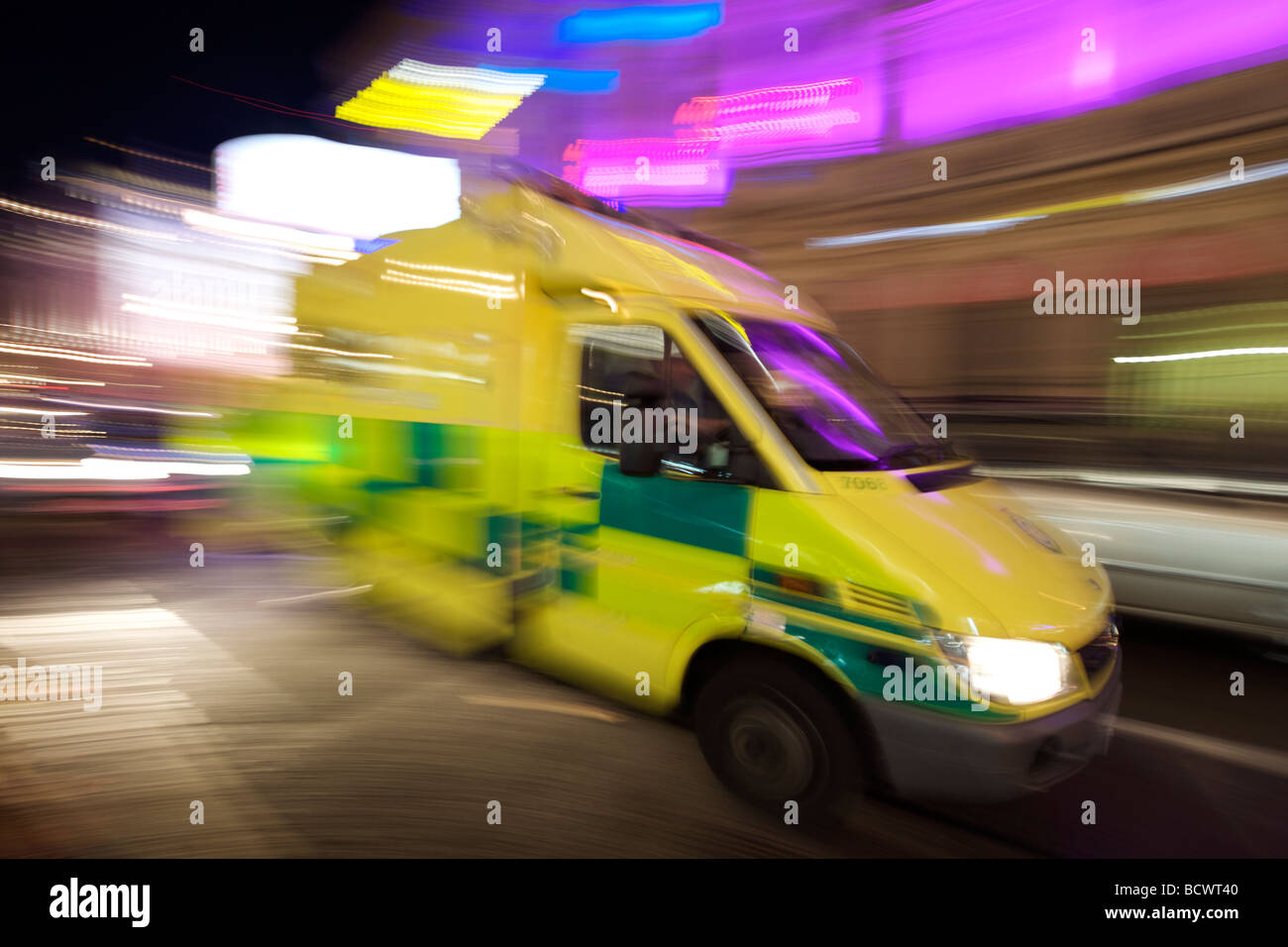 Un ambulanza corre lungo una strada di Londra di notte. Foto Stock