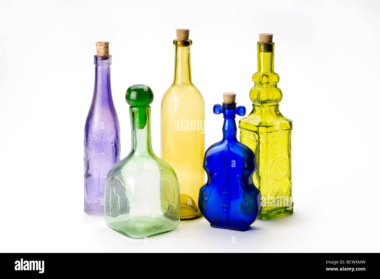 Colorate le bottiglie di vetro su bianco Foto Stock
