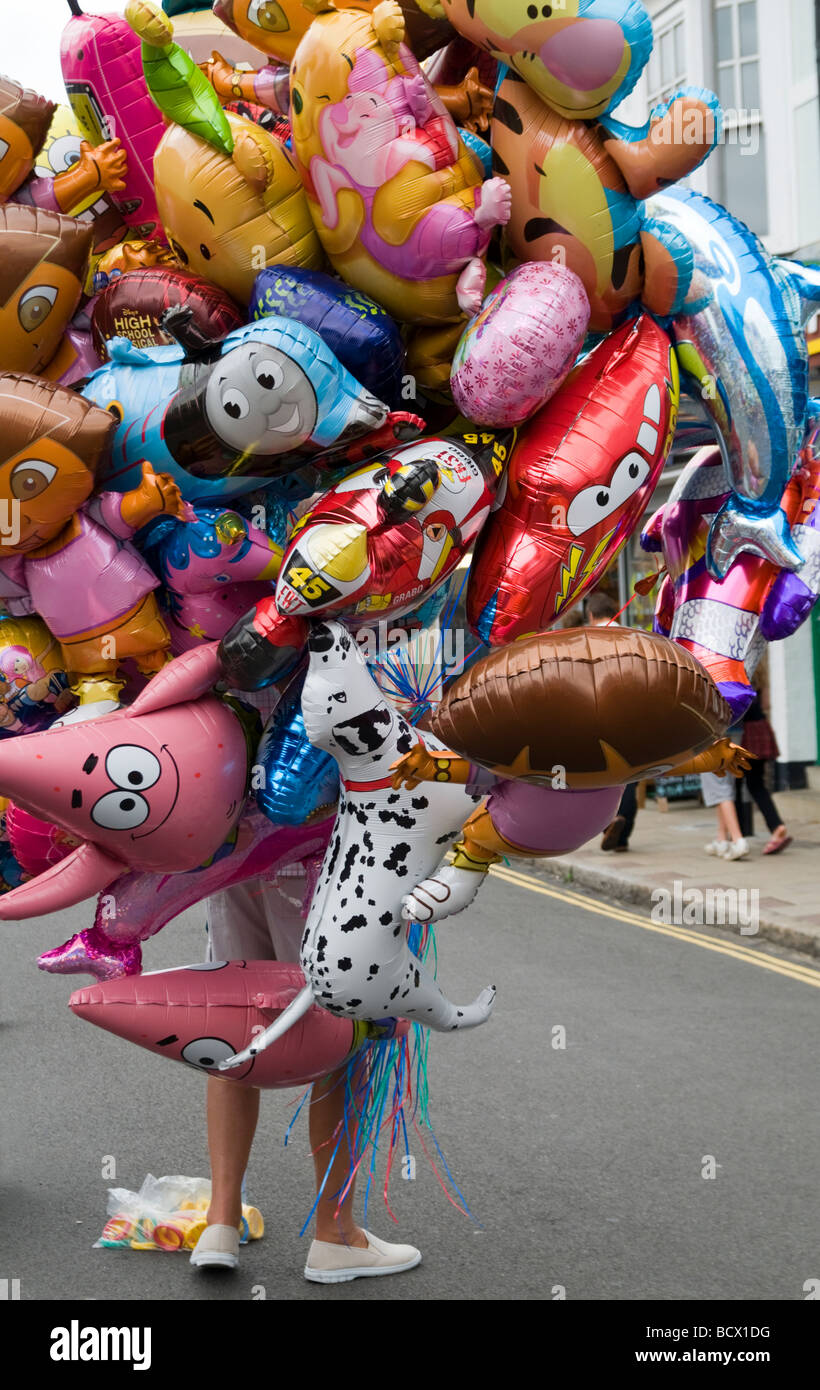 Persona che porta con sé una grande collezione di palloncini gonfiabili Norfolk Inghilterra Foto Stock