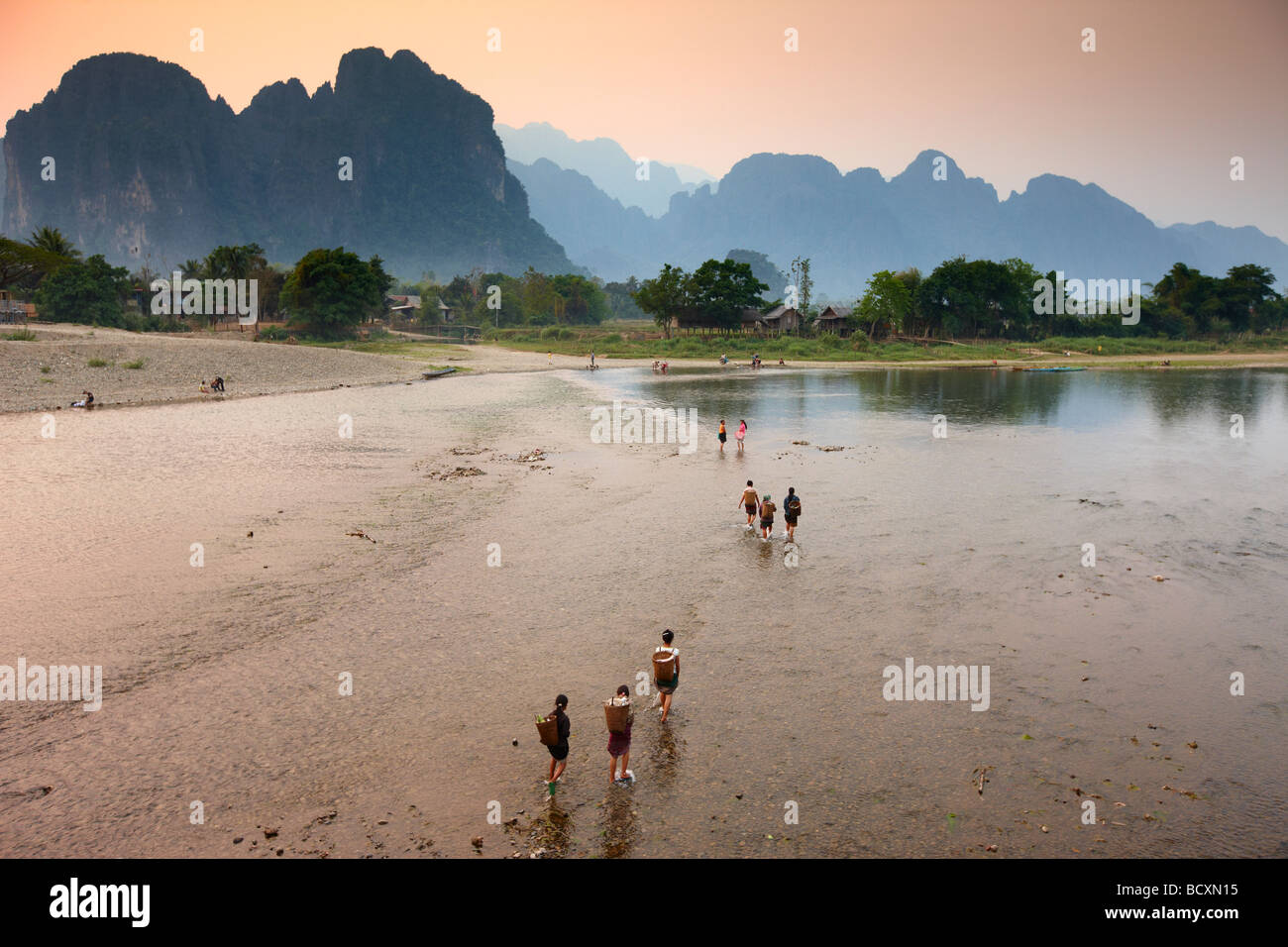 Donne guadare il Nam Song River a Vang Vieng, Laos Foto Stock