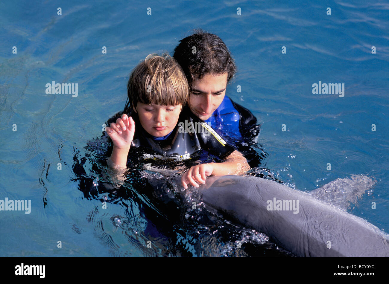 Bambino autistico riceve la terapia con dolphin trainer e Bottlenose Dolphin Foto Stock