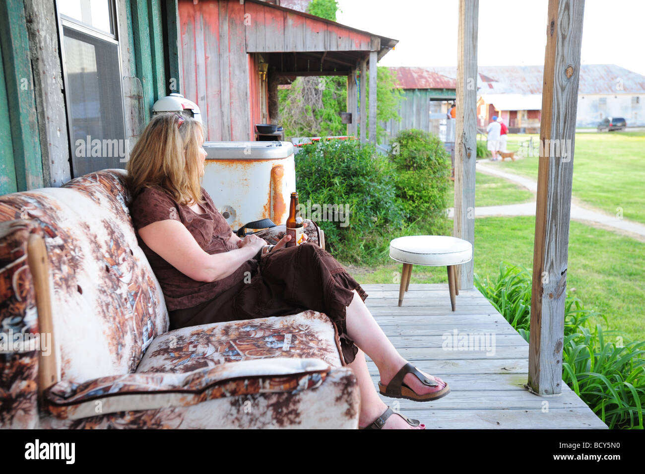 Stati Uniti Mississippi Clarksdale Shack fino Inn hotel donna avente una birra su un portico Foto Stock