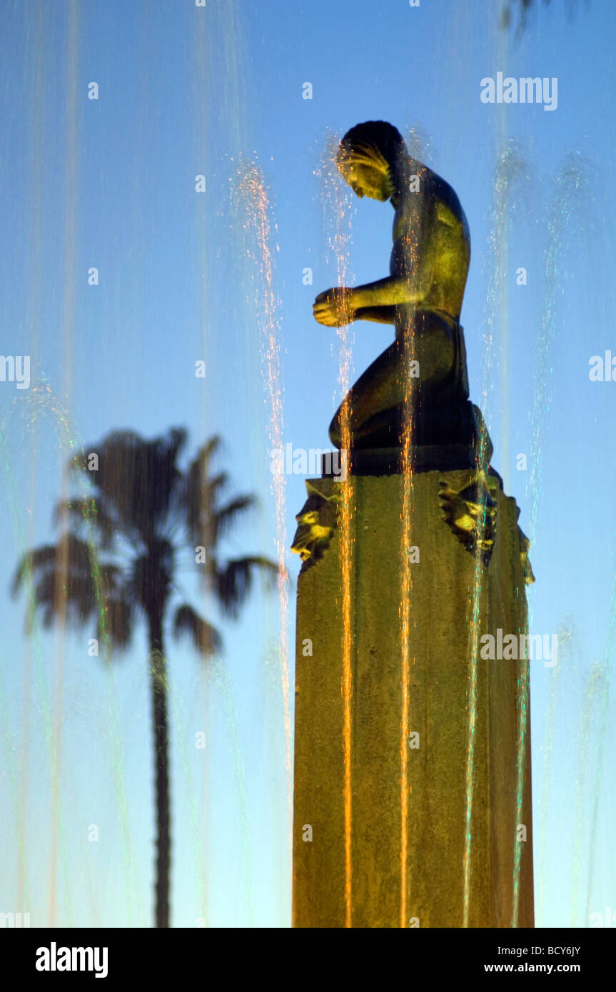Fontana con personaggio inginocchiato al tramonto a Beverly Hills, California Foto Stock
