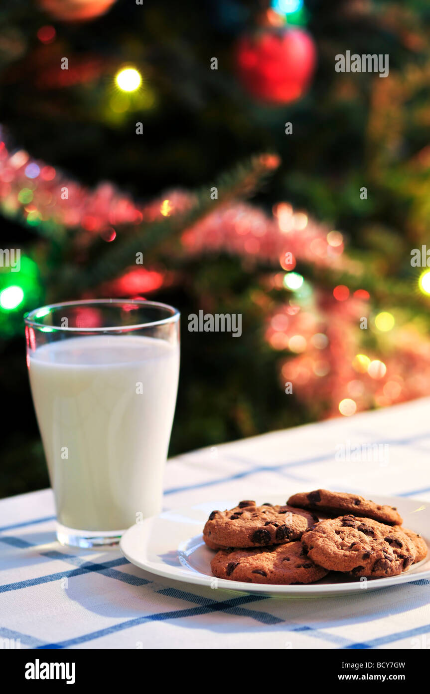 Piastra del cookie e bicchiere di latte nei pressi di albero di Natale Foto Stock