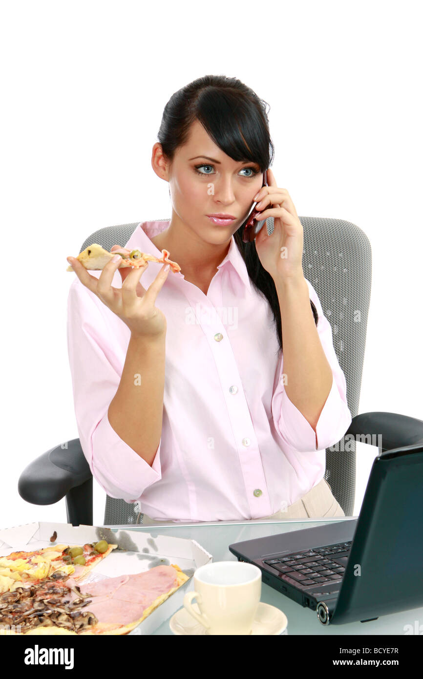 Junge Frau isst Pizza Buero im imprenditrice mangiare la pizza in ufficio Foto Stock