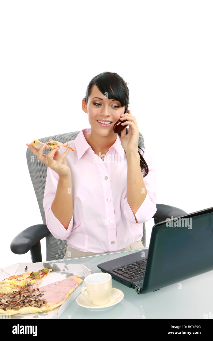 Junge Frau isst Pizza Buero im imprenditrice mangiare la pizza in ufficio Foto Stock