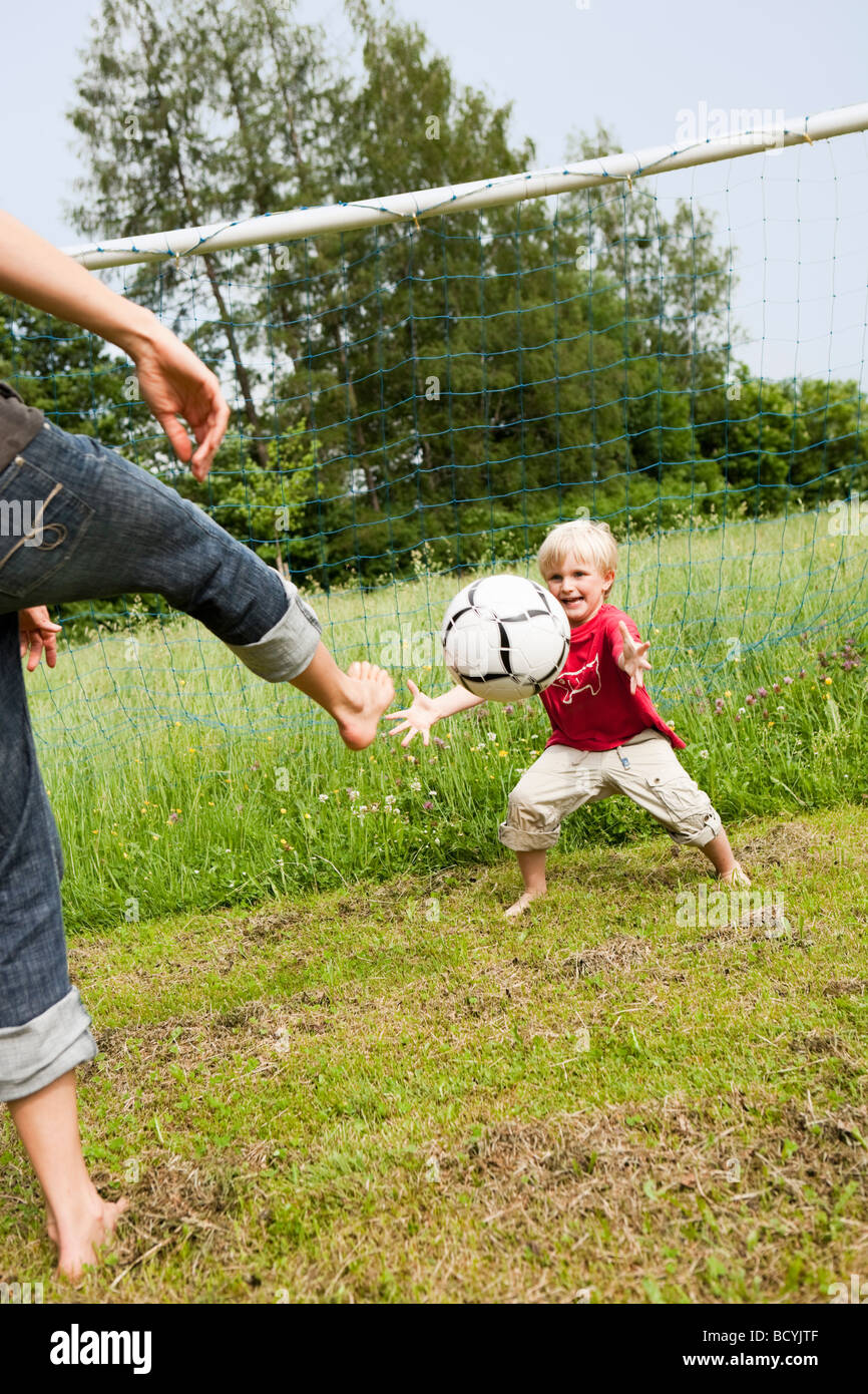 La madre e il figlio che giocano a calcio Foto Stock