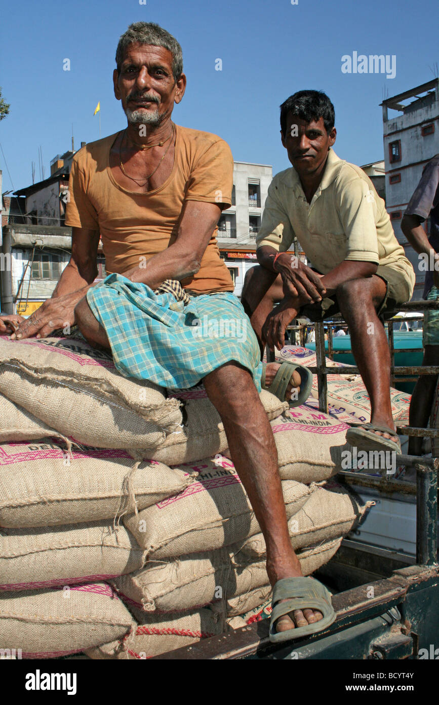 Due uomini indiano resto sui sacchi di riso presi in Jorhat, Stato di Assam Foto Stock