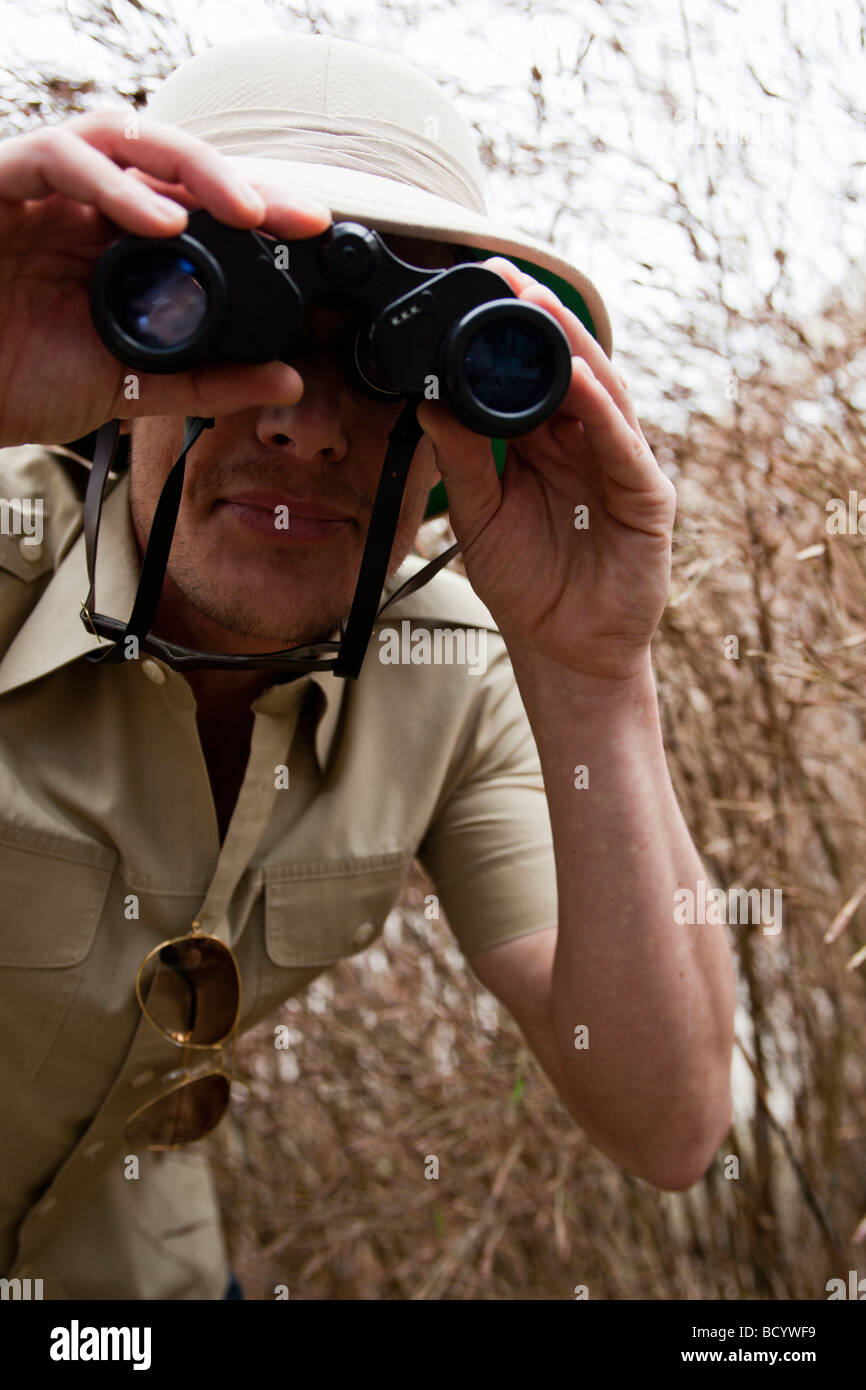 L uomo nella giungla vestito con il binocolo Foto Stock