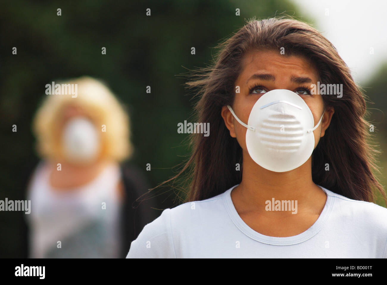 due giovani donne in strada indossando anti inquinamento, virus corona, maschere filtro Foto Stock