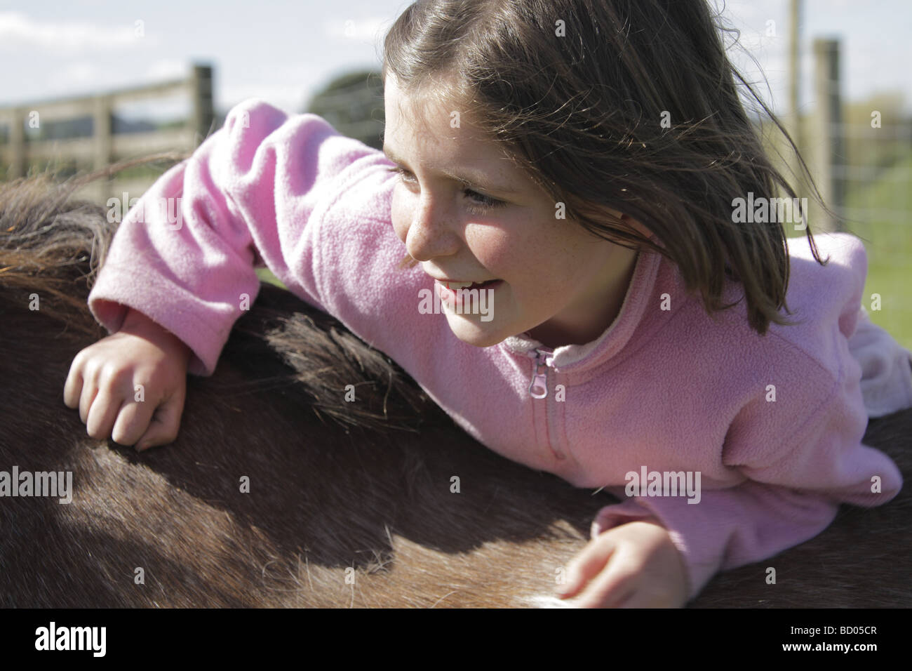 Ragazza giovane arrampicata su cavalli indietro Foto Stock