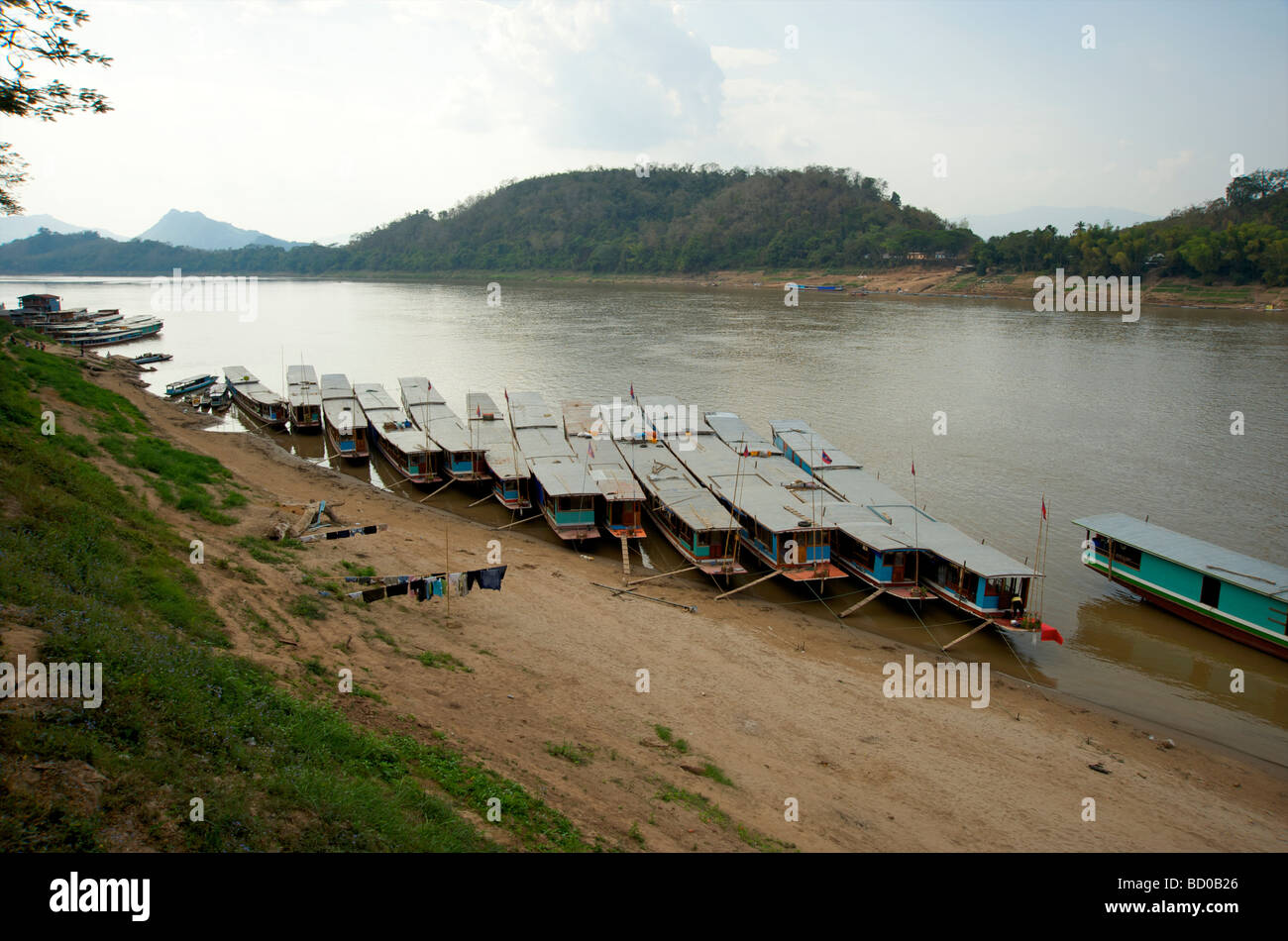 Lento in legno barche ormeggiate sulle rive del fiume Mekong a Luang Prabang, Laos Foto Stock