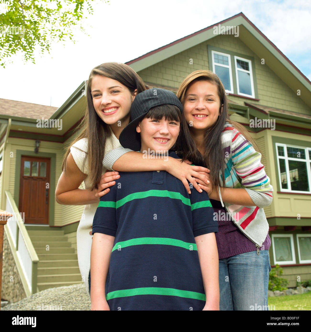 Tre bambini sorridenti davanti la casa, Victoria, British Columbia Foto Stock