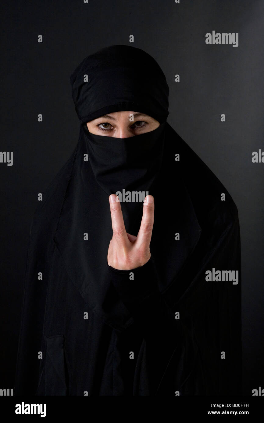 Islam donna musulmana che indossa un burqa niqab burka e facendo un segno v Foto Stock