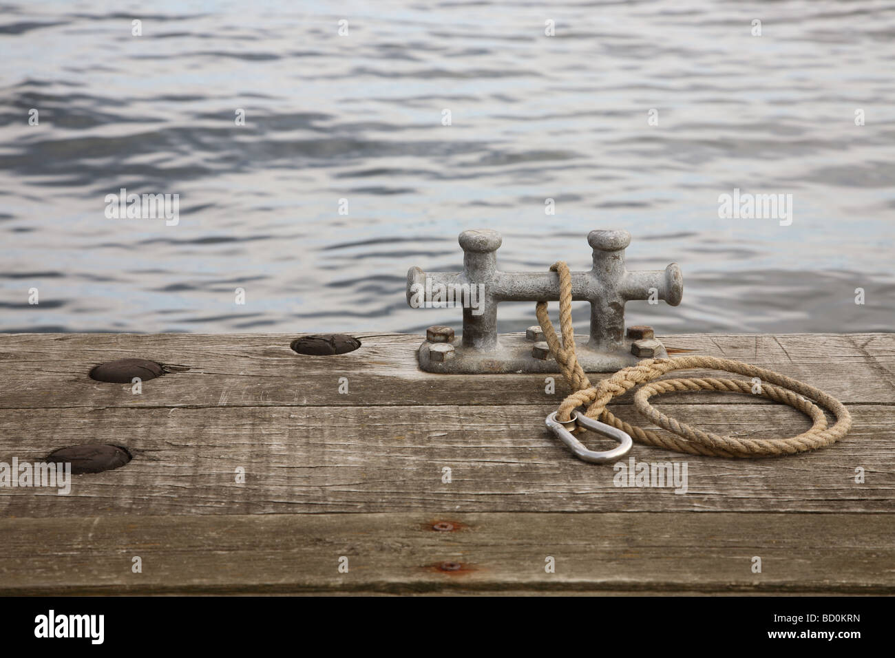 Posto barca bitt con corda e gancio a scatto su di un pontile in legno. Foto Stock