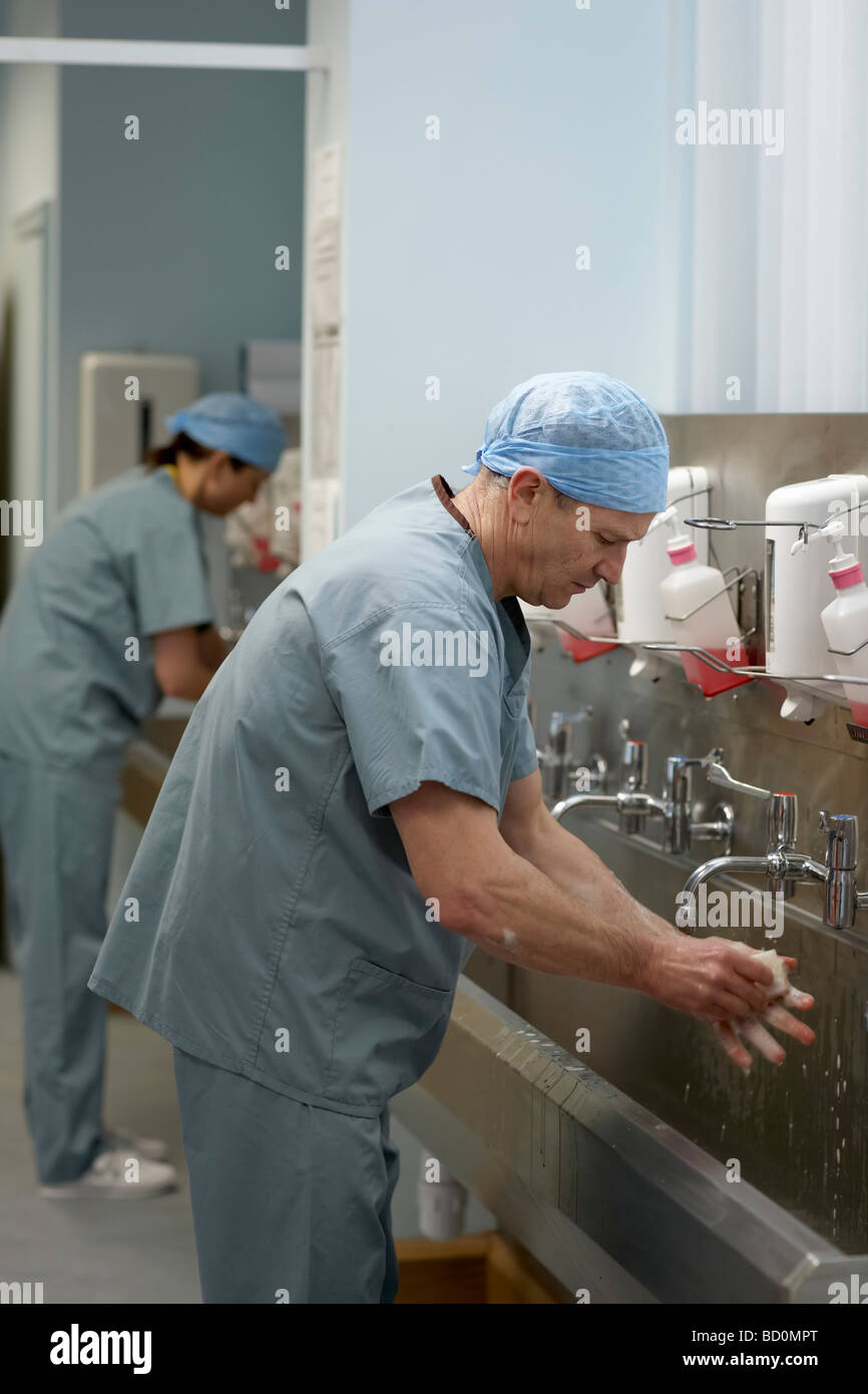 Il personale medico in scrubs lavaggio delle mani Foto Stock