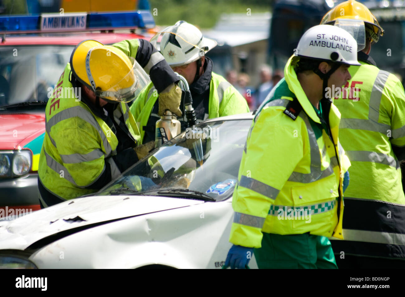 Gli equipaggi di incendio utilizzare ganasce della vita per rilasciare un passeggero da un crash car. Foto Stock