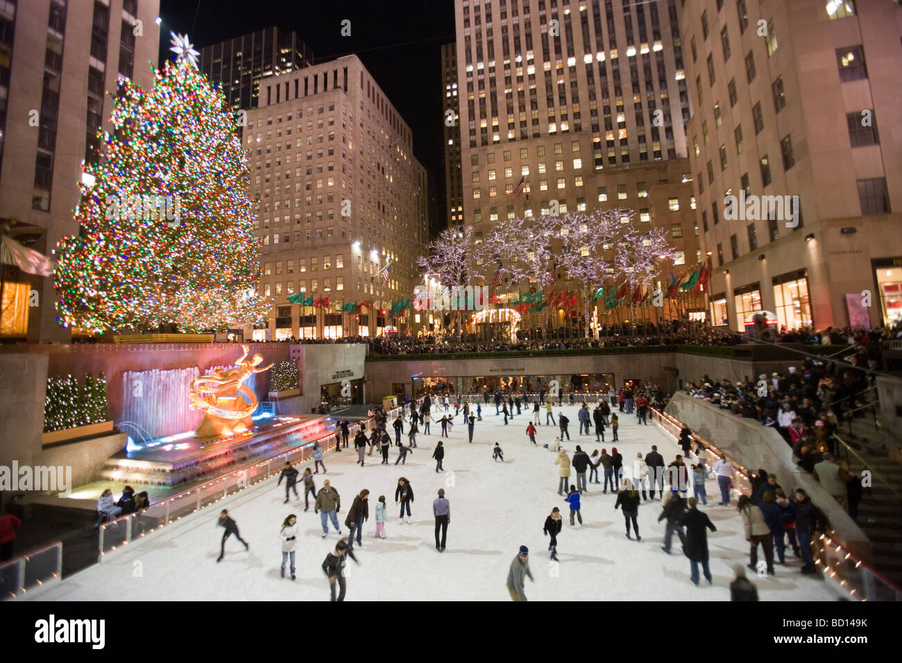 Pattinaggio sul ghiaccio in pista per il pattinaggio sul ghiaccio presso l albero di Natale al Rockefeller Center di notte. Foto Stock