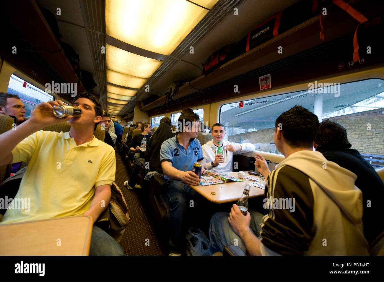 Bianchi Giovani maschi europei celebrare in un viaggio in treno. Foto Stock