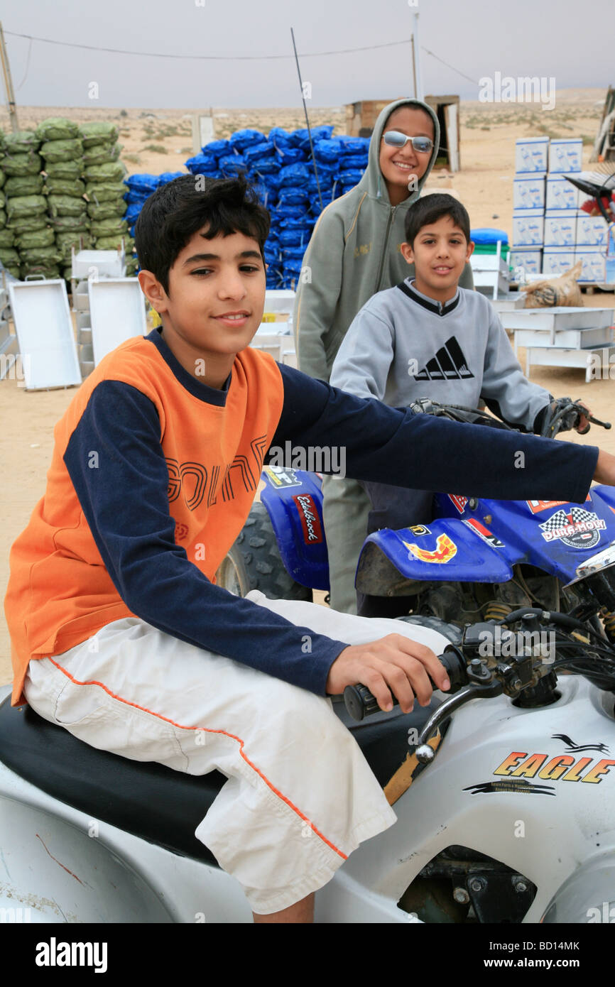 Giovane arabo bambini seduti sul quad bikes Kuwait Foto Stock