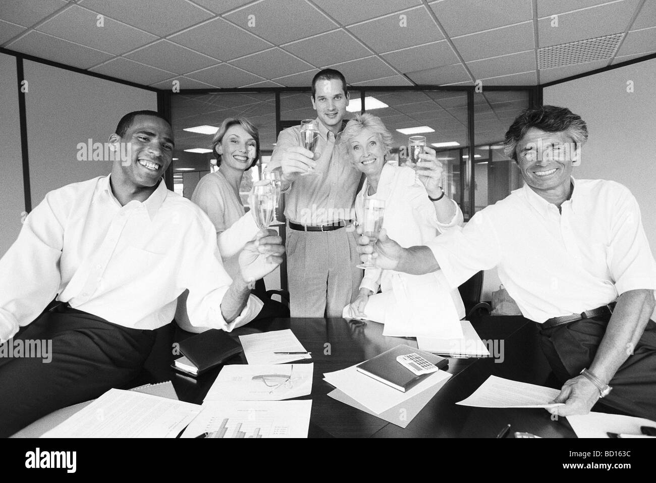 I soci dell'azienda celebrando con champagne in ufficio Foto Stock