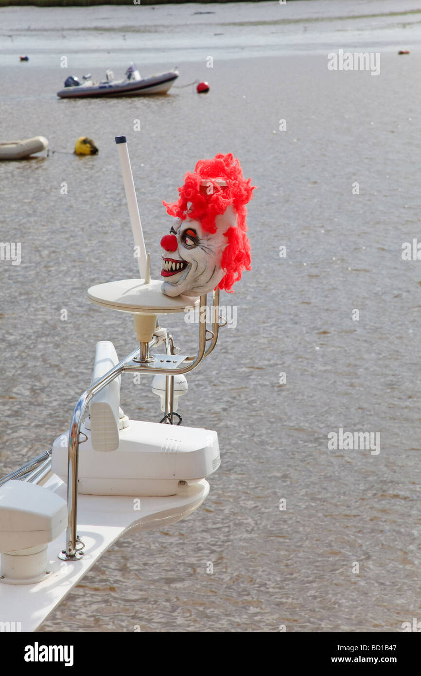 Un pauroso Clown maschera sul radar antenne di una barca a motore sul fiume Exe a Topsham progettato per mantenere gli uccelli dal appollaia Foto Stock