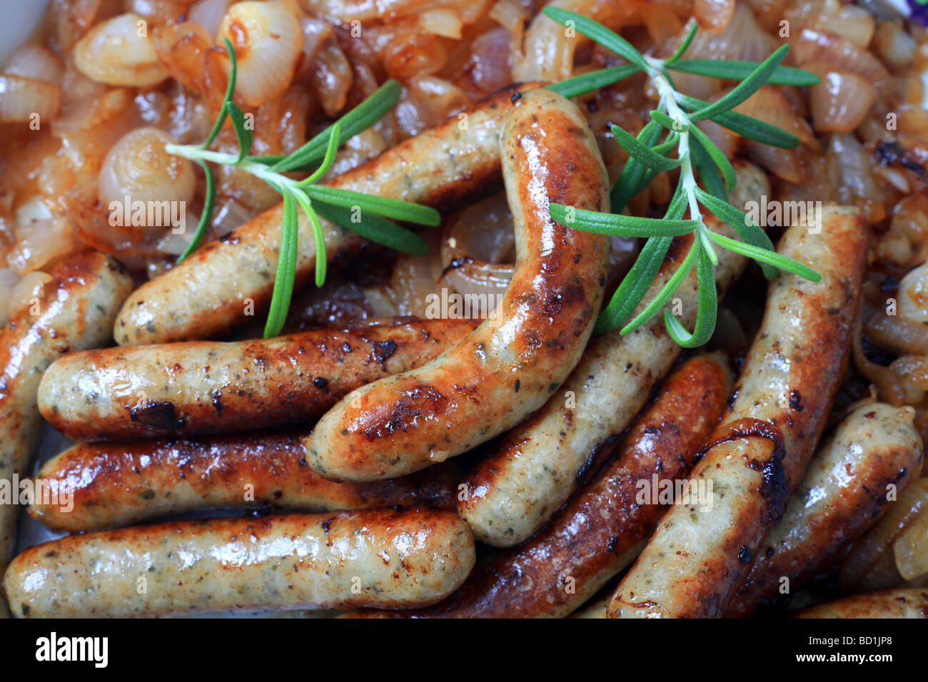 Vista ravvicinata di salsicce fritte e le cipolle in una ciotola Foto Stock