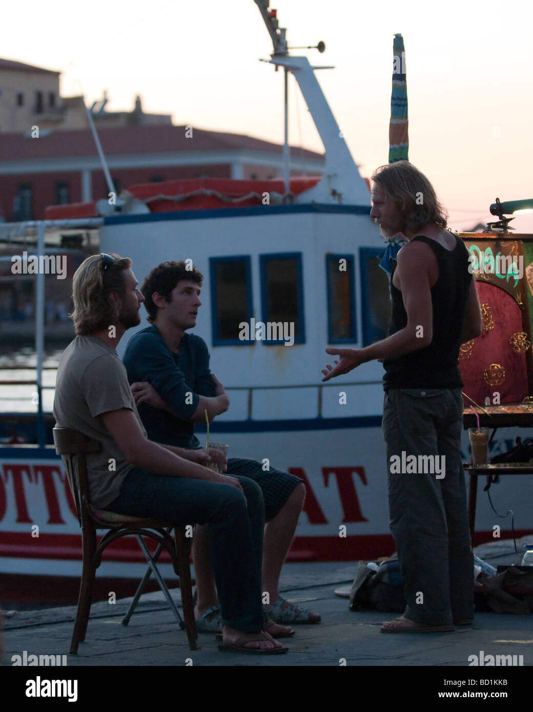 Gli artisti locali di parlare al tramonto a Porto Vecchio, Chania Creta Grecia Foto Stock