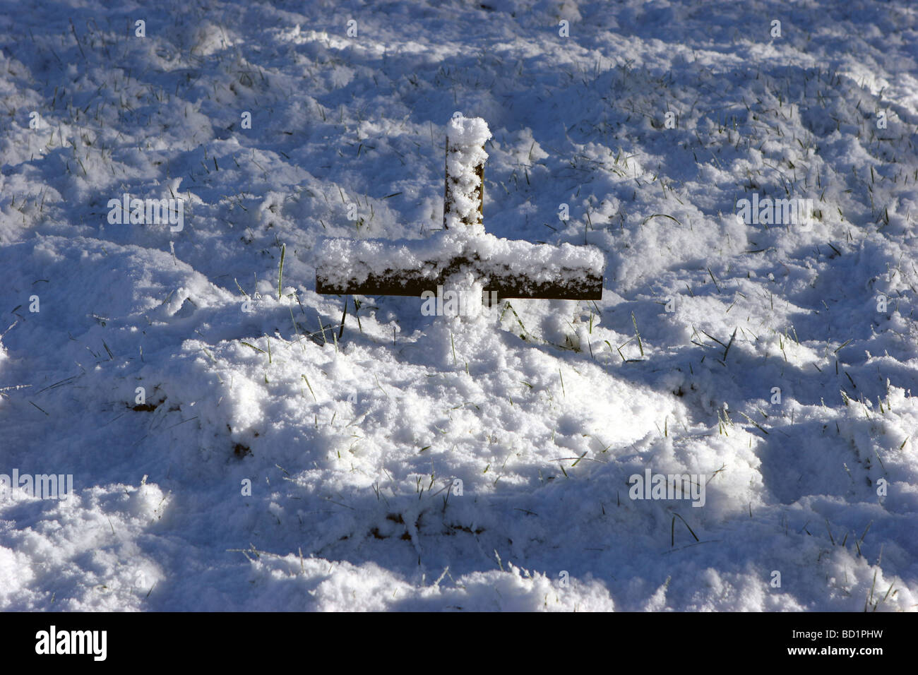 Una coperta di neve croce su una tomba Foto Stock